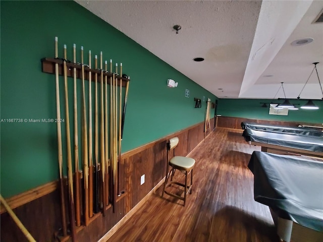 interior space with pool table, a textured ceiling, and hardwood / wood-style flooring