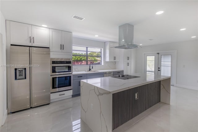 kitchen featuring appliances with stainless steel finishes, white cabinetry, sink, and island exhaust hood