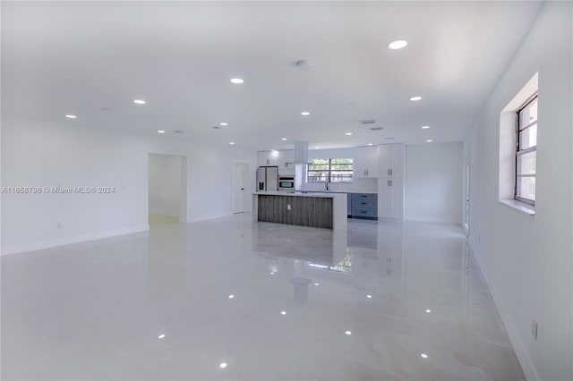 kitchen featuring a spacious island, white cabinets, appliances with stainless steel finishes, and a wealth of natural light