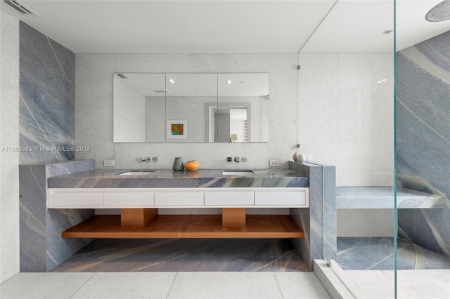 bathroom with walk in shower, vanity, tile walls, and tile patterned floors