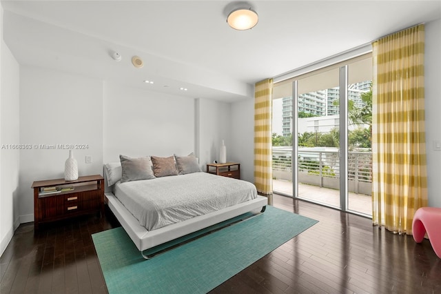 bedroom featuring a wall of windows, access to outside, and dark hardwood / wood-style flooring