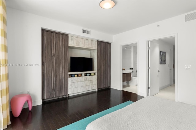 bedroom with connected bathroom and light hardwood / wood-style flooring