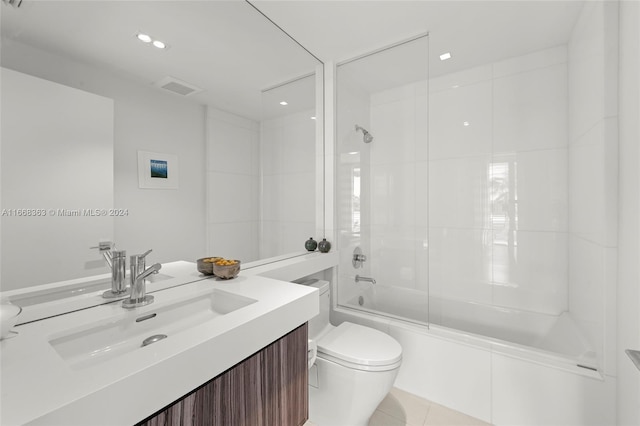 full bathroom featuring tile patterned floors, tiled shower / bath combo, vanity, and toilet