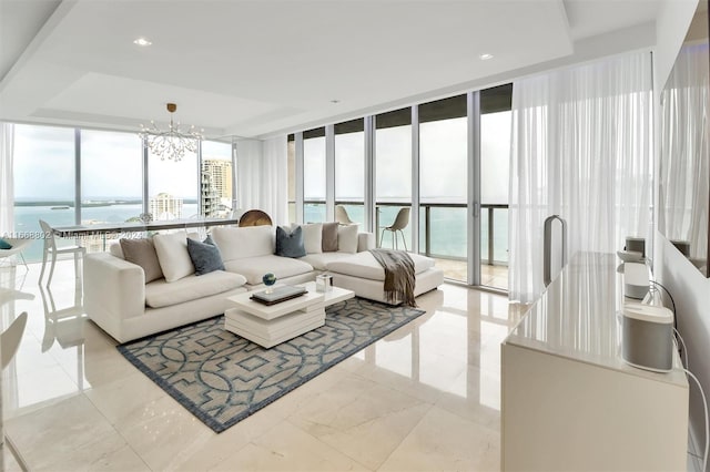 living room with an inviting chandelier, a wall of windows, and a water view