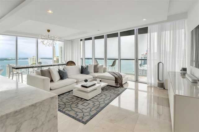 living room featuring floor to ceiling windows, a water view, and a chandelier