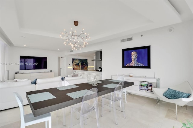 dining area with a notable chandelier and a raised ceiling