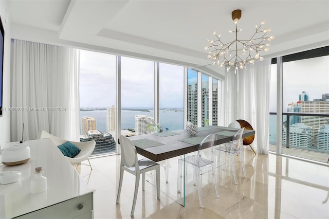 dining area with a notable chandelier, a wealth of natural light, a water view, and floor to ceiling windows