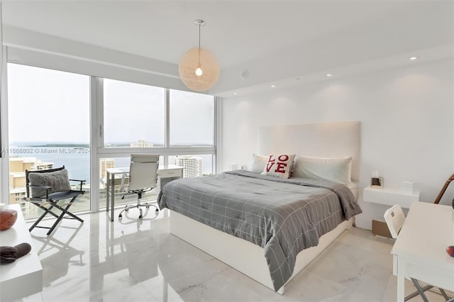 bedroom with a water view and expansive windows