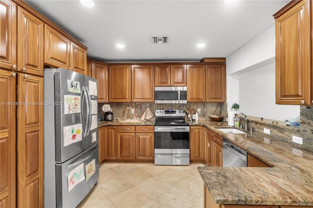 kitchen featuring stone countertops, sink, and stainless steel appliances