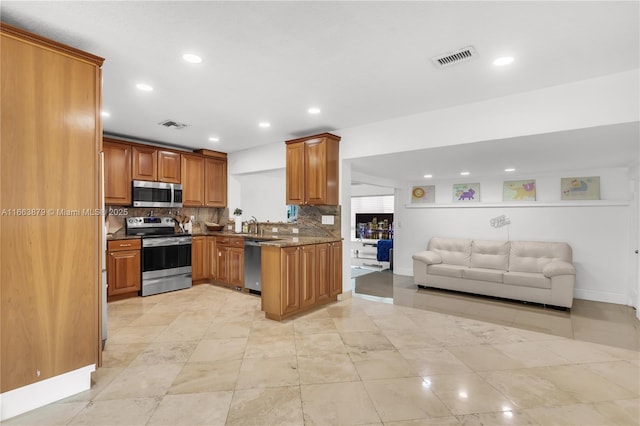 kitchen featuring appliances with stainless steel finishes, backsplash, light tile patterned floors, and dark stone counters