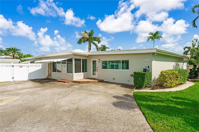 back of property featuring a sunroom and a yard