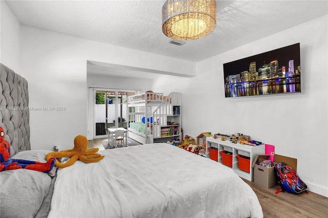 bedroom featuring hardwood / wood-style flooring and a textured ceiling