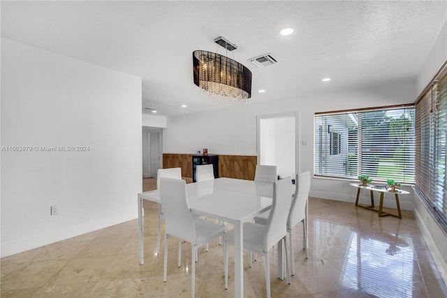 dining room featuring a textured ceiling and an inviting chandelier