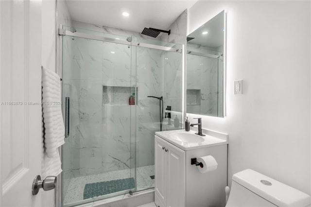 bathroom with vanity, an enclosed shower, and toilet