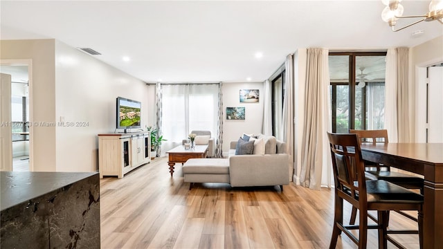 living room featuring light wood-type flooring and an inviting chandelier