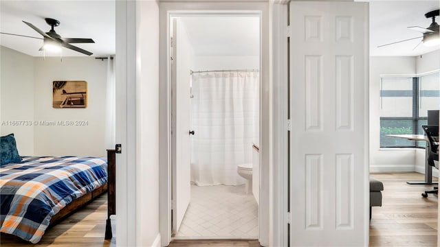 bedroom featuring ceiling fan, light wood-type flooring, and ensuite bath