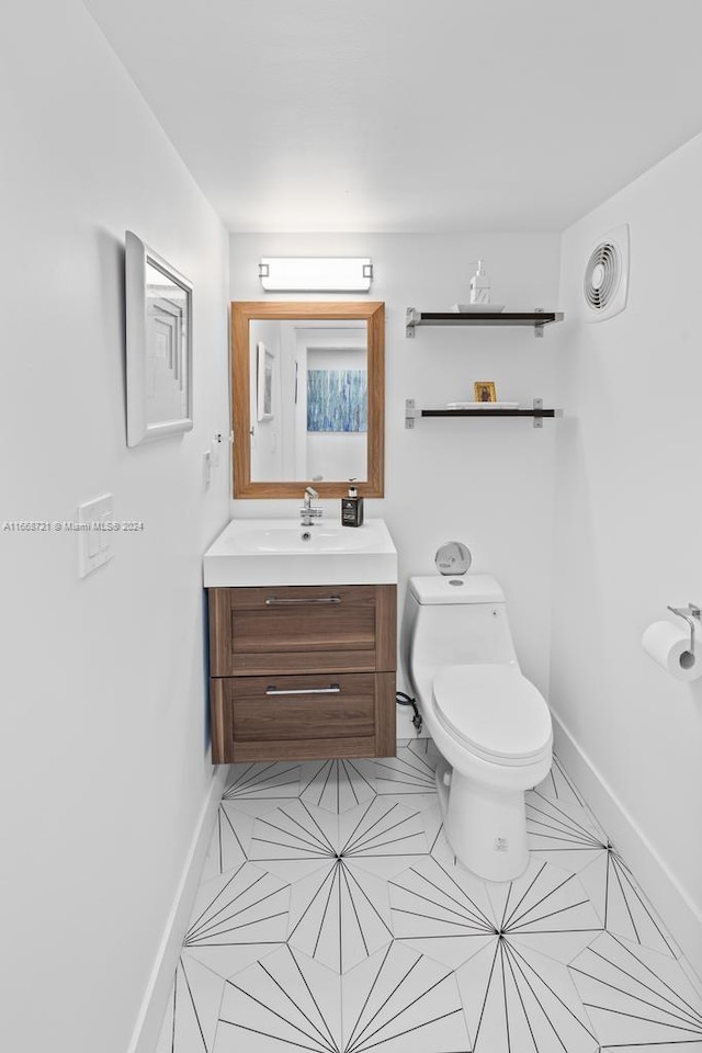 bathroom with vanity, toilet, and tile patterned floors