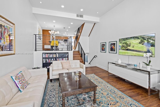 living room featuring an inviting chandelier, dark wood-type flooring, and high vaulted ceiling