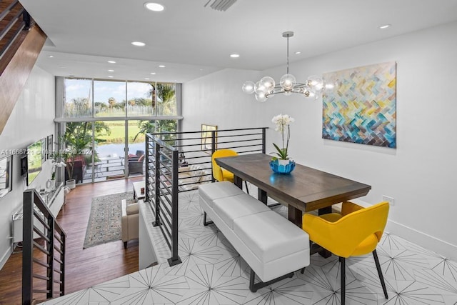 dining space featuring an inviting chandelier, light wood-type flooring, and a wall of windows