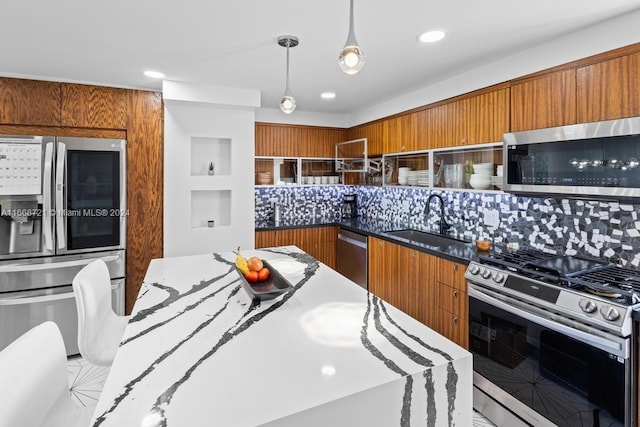 kitchen with stainless steel appliances, hanging light fixtures, sink, and decorative backsplash