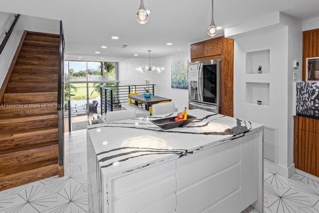 kitchen with a center island, a chandelier, stainless steel appliances, and white cabinets