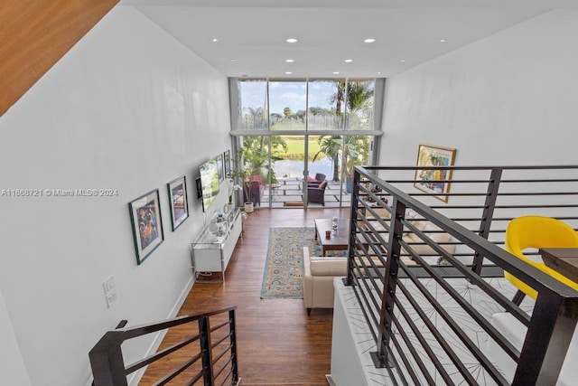 hallway with a wall of windows and dark hardwood / wood-style floors