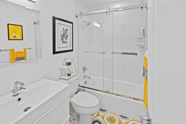 full bathroom featuring combined bath / shower with glass door, vanity, and toilet