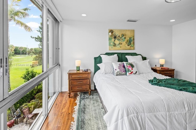 bedroom featuring hardwood / wood-style floors and multiple windows