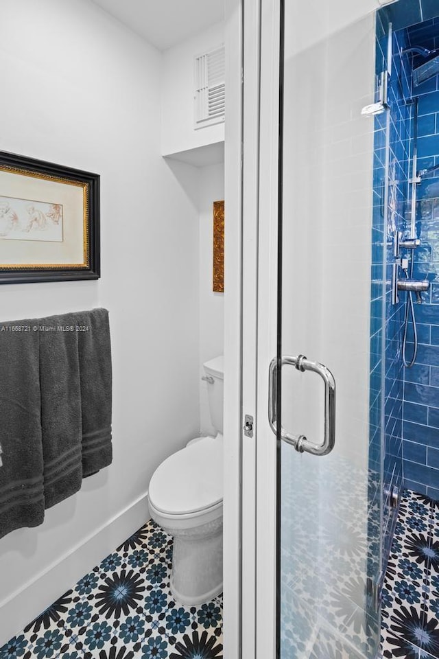 bathroom with tile patterned flooring, walk in shower, and toilet