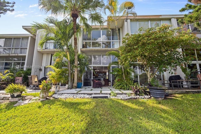 rear view of house with a patio and a yard