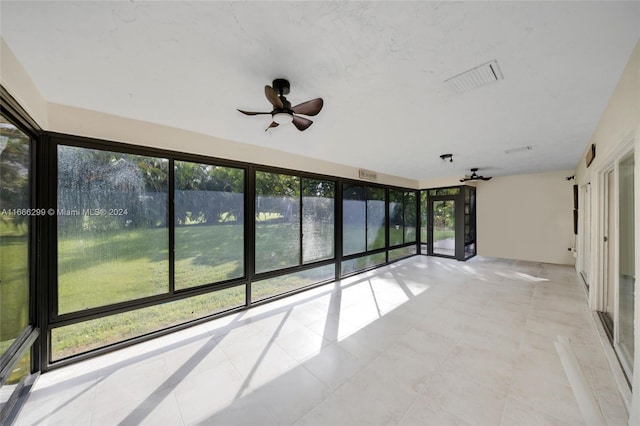 unfurnished sunroom featuring a water view and ceiling fan