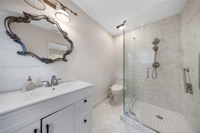 bathroom with vanity, toilet, and a tile shower