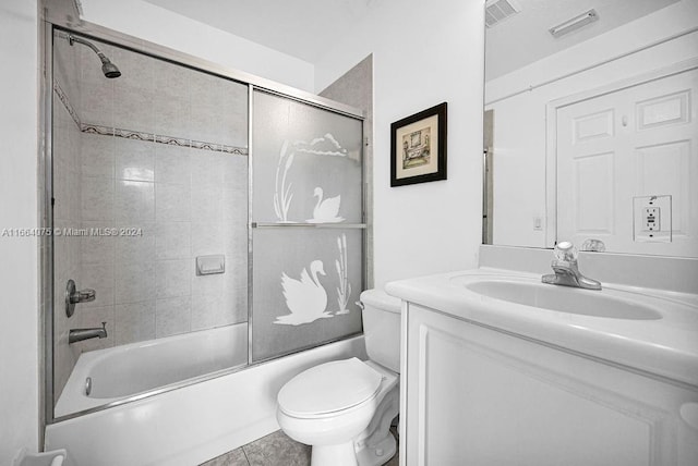 full bathroom with shower / bath combination with glass door, tile patterned flooring, vanity, and toilet