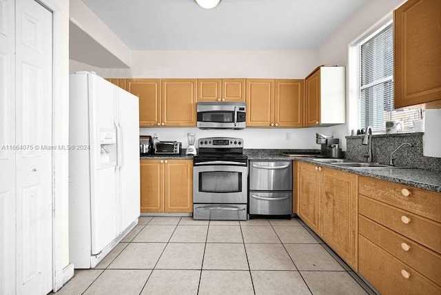 kitchen featuring appliances with stainless steel finishes, sink, and light tile patterned floors