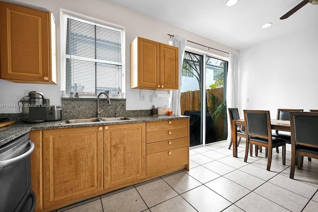 kitchen with ceiling fan, stainless steel dishwasher, light tile patterned floors, and sink