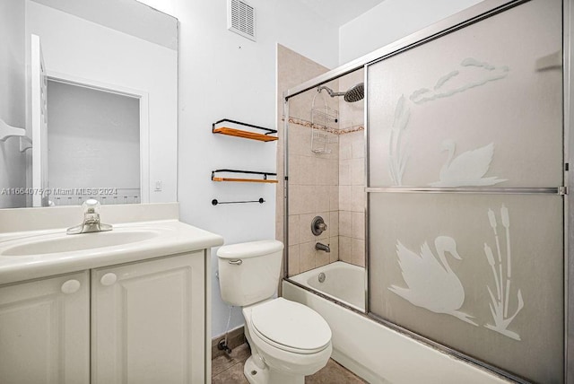 full bathroom featuring combined bath / shower with glass door, vanity, toilet, and tile patterned floors