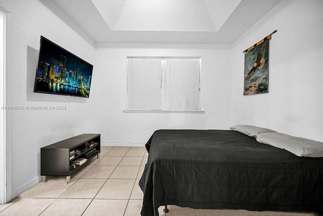 tiled bedroom with a tray ceiling