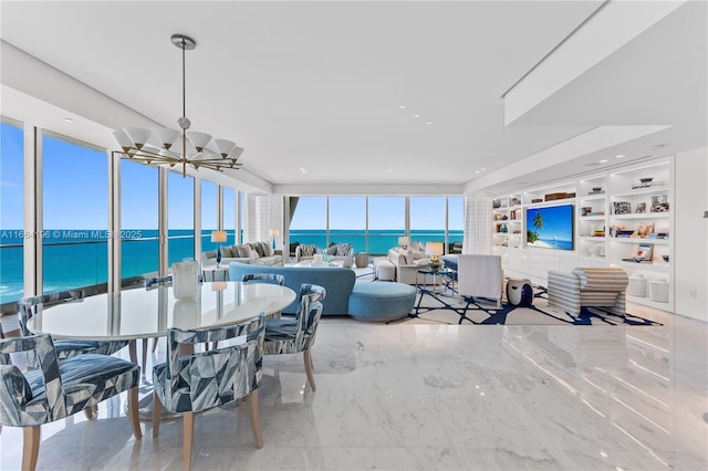 dining space featuring a water view, a chandelier, and built in features