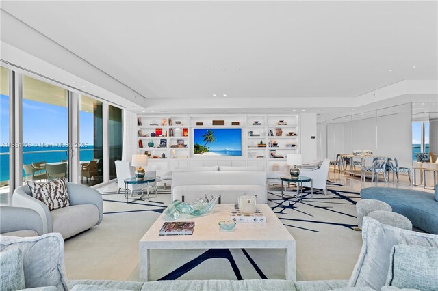 living room with a water view, plenty of natural light, and built in features