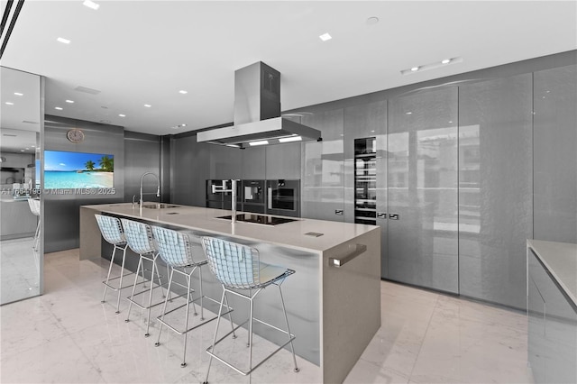 kitchen featuring sink, a breakfast bar, a spacious island, black electric stovetop, and island range hood