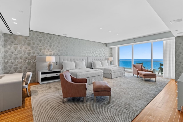 living room with a water view and light hardwood / wood-style floors