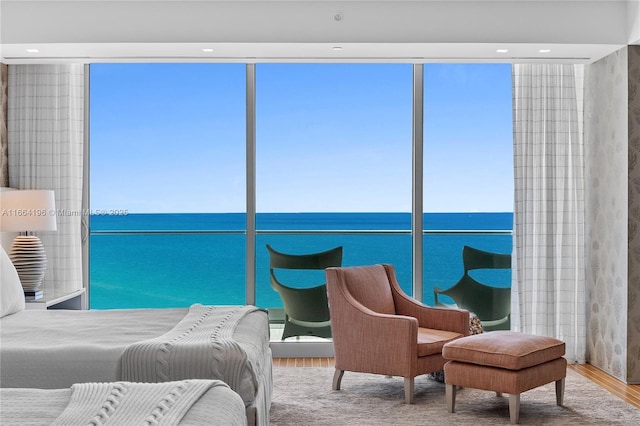 bedroom featuring hardwood / wood-style floors and a water view