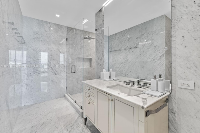 bathroom featuring walk in shower, vanity, and tile walls