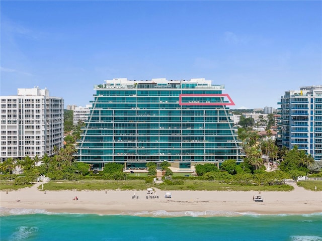 view of building exterior with a beach view, a view of city, and a water view