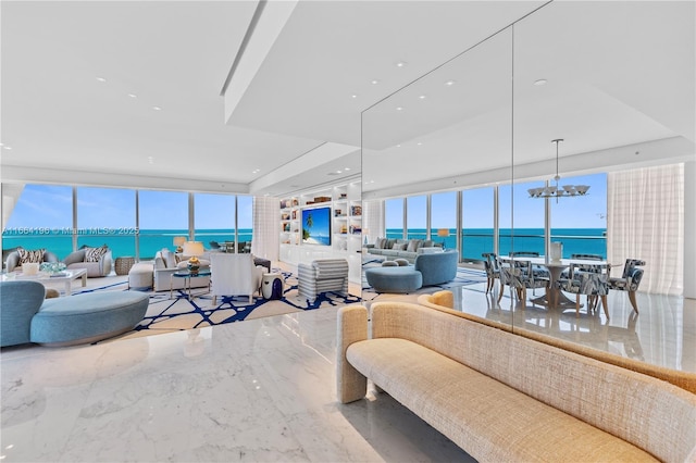 living area featuring a water view, a wall of windows, marble finish floor, and a notable chandelier
