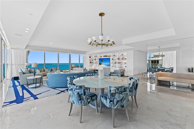 dining room with a tray ceiling, built in shelves, and a chandelier