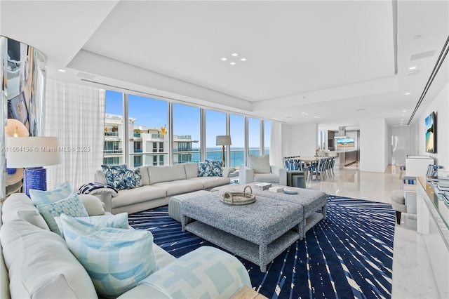 living room with a raised ceiling and a water view