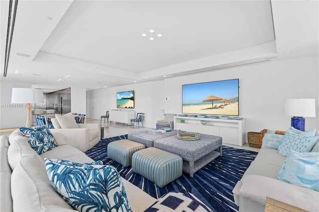 living room featuring recessed lighting and a raised ceiling