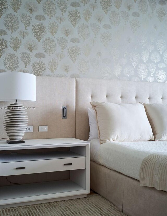 bedroom with light wood-type flooring, a water view, and access to exterior