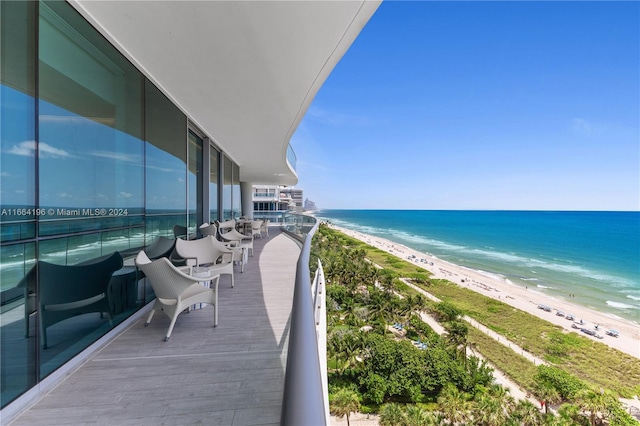 balcony with a water view and a beach view